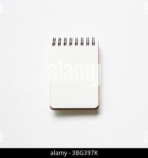 Empty spiral notebook on white painted background. top view, copy space Stock Photo