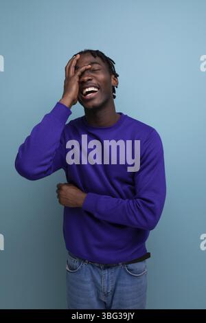 Positive black american young guy with dreadlocks smiling and joking Stock Photo