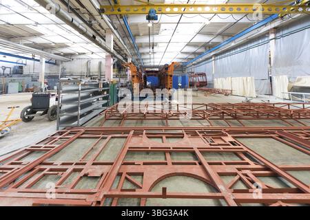 One working day of modern automatic bus trolleybus car production with unfinished cars workers in protective uniform in factory background automobile Stock Photo