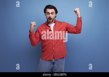 Young european handsome guy with a stylish hairstyle rejoices Stock Photo