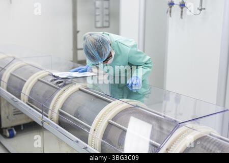 Scientist is making notes about a machine Stock Photo