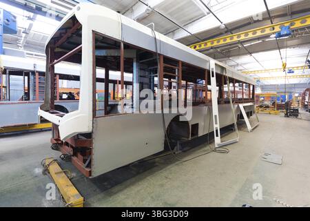 One working day of modern automatic bus trolleybus car production with unfinished cars workers in protective uniform in automotive background automobi Stock Photo