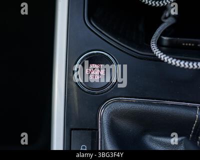 This image highlights a sleek engine start/stop button inside a modern vehicle, typically located on the dashboard, offering keyless ignition function Stock Photo