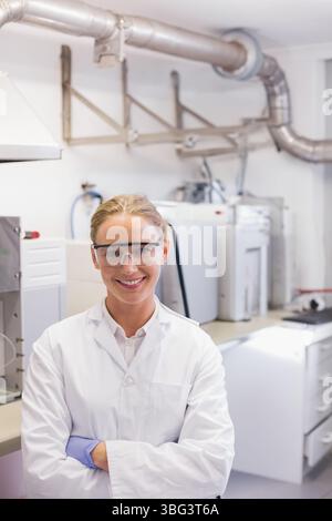 Female lab technician wearing lab coat and gloves operating analytical instruments at lab bench Stock Photo