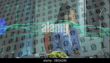 Image of data processing over african american female server room worker using laptop Stock Photo