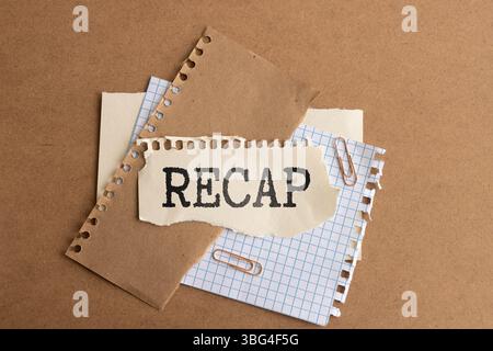 The text recap appearing behind torn yellow paper Stock Photo