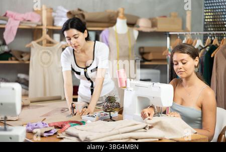 Two female tailors working on custom garment in studio Stock Photo