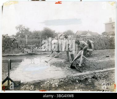 Photograph from 1912 showing African American workers pouring and leveling concrete for a brick road foundation. Brick was commonly used in paving Ohio’s roads and required extensive manual labor. Stock Photo