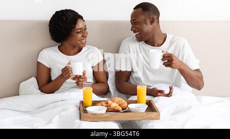 Loving african american family having breakfast in bed Stock Photo