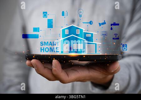 Hand holding smartphone with smart home interface, showing connected devices and automation technology. Concept of modern living, convenience, innovat Stock Photo