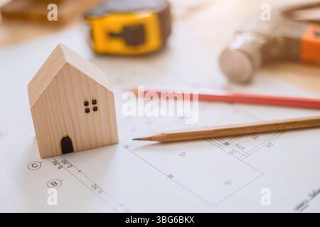 small wooden home on architect floor plan, House designer architecture blue print background concept Stock Photo