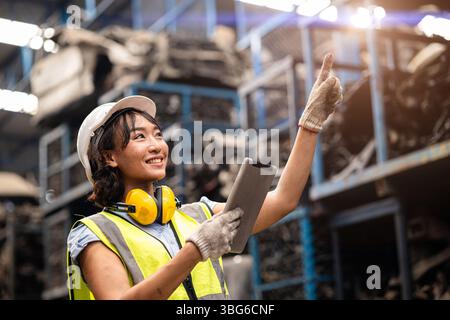 Happy Black Asian women technician engineer hardware stock warehouse worker enjoy working in heavy industry. Stock Photo