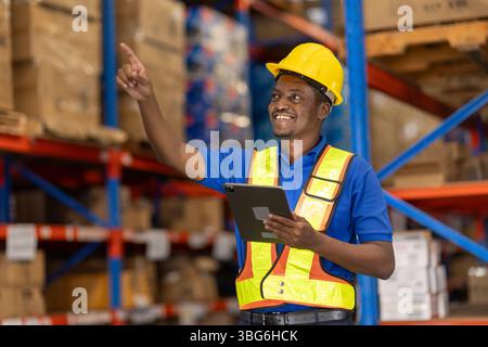 Young smart African American man working in warehouse using tablet for stock checking and counting boxes at shelf, logistic warehouse to deliver the s Stock Photo