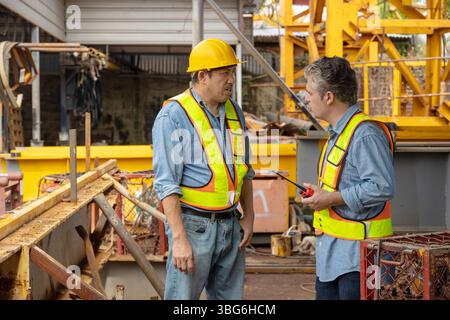Construction engineer team working together join teamwork talking together at construction site Stock Photo