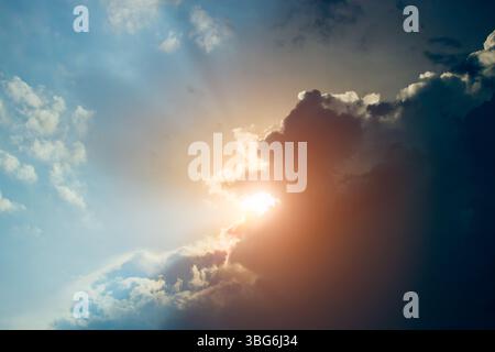 raining dark storm clouds are coming hiding pass the sunlight. The rainy season is coming. Stock Photo