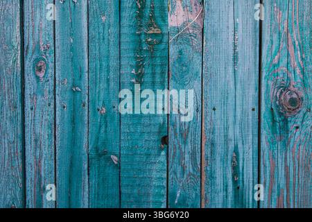 Old green painted wooden boards with peeling paint, visible wood grain, and natural textures. Sunlight casts soft shadows across the surface, ideal fo Stock Photo