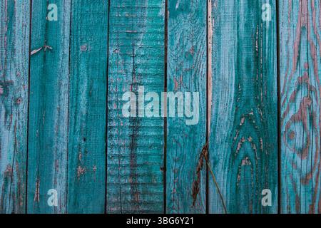 Old green painted wooden boards with peeling paint, visible wood grain, and natural textures. Sunlight casts soft shadows across the surface, ideal fo Stock Photo