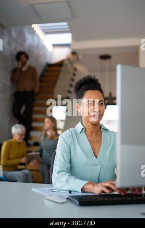 Black woman working in office and futuristic graphical user interface concept. System engineering. Stock Photo