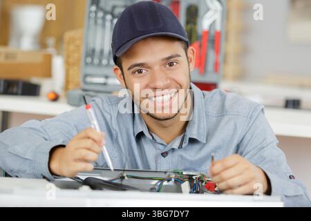 young serviceman repairing washing machine Stock Photo