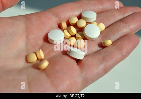Pills in hand. Close-up of a palm holding medications. Stock Photo