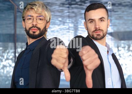 Two confident businessmen in suits giving thumbs down and smiling at camera Stock Photo