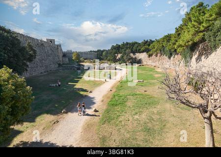 Rodas.Greece - june 04, 2025: Tranquil pathway winding through the ancient moats of Rhodes, offering a glimpse into the city's rich past. Stock Photo