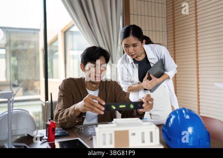 ESG Principles in Action. Architects reviewing a building model for sustainable construction. Stock Photo