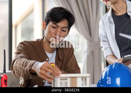 ESG in Architecture. Young professionals collaborating on sustainable building design. Stock Photo