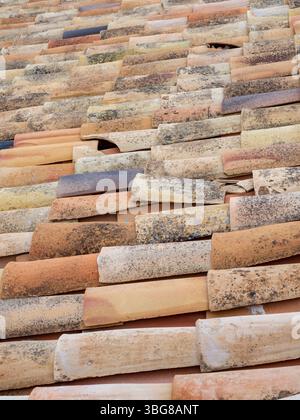 broken clay pantile tiles on a roof prior to being replaced Stock Photo