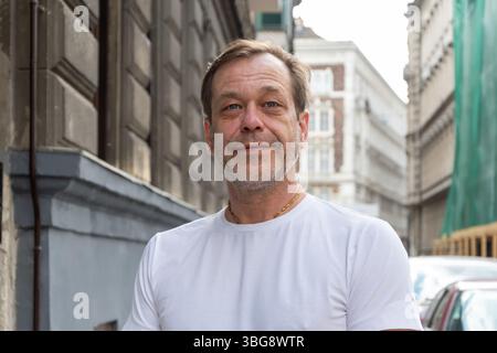 Close-up of the face of a man of 50-55 years old with a beard and moustache, shot in the street. The expression of the face is calm and friendly Stock Photo