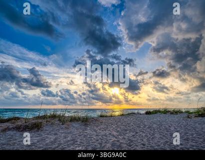 Sunset with dramatic clouds in sky over the Gulf of Mexico near the Venice Fishing Pier in Venice Florida USA Stock Photo