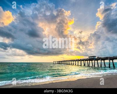 Sunset with dramatic clouds in sky over the Gulf of Mexico at the Venice Fishing Pier in Venice Florida USA Stock Photo