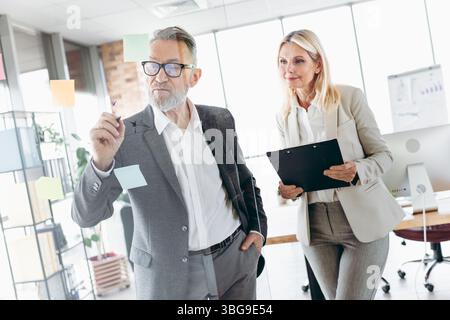 Senior executives collaborating on office strategy with teamwork and innovative ideas, fostering successful professional partnerships Stock Photo