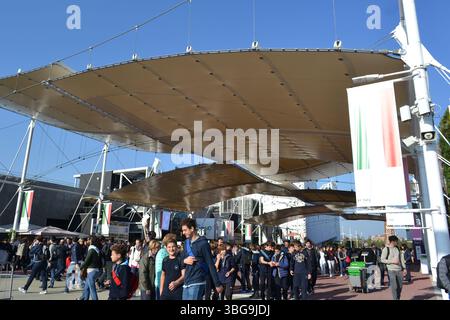 Panoramic view of the big tops of Decumano Street and enormous crowd of people passing along the avenue looking for expo curiosities all around. Stock Photo