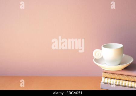 Stack of notebook and coffee cup on orange table. pink wall background with copy space Stock Photo