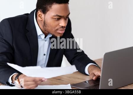 African american manager checking marketing report, using laptop Stock Photo