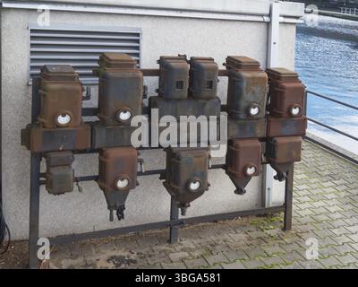 Old electrical connection boxes on a white wall Stock Photo