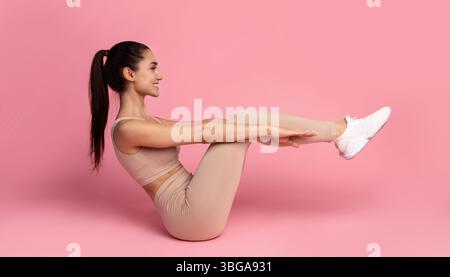 Smiling Young Woman Doing Abs Exercise With Leg Raise Stock Photo