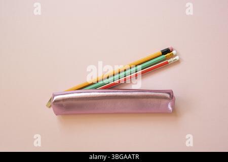Pink pencil case with writing supply isolated on pink background. top view Stock Photo