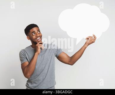 African-american man holding blank speech bubble on white Stock Photo