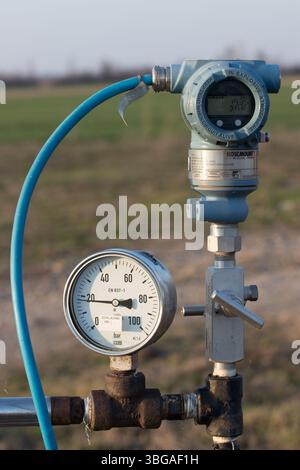 Pressure Reader From Machine Machine pipe with pressure gauge in empty factory Stock Photo - Alamy