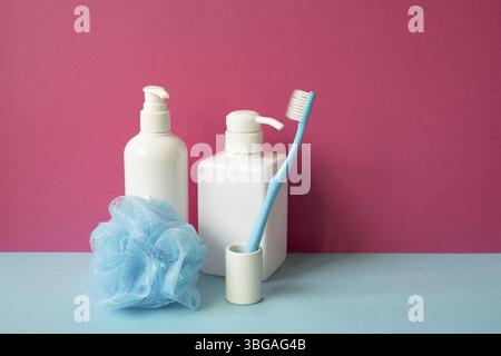 Bathroom object. Shampoo and soap dispenser, toothbrush, shower ball on skyblue shelf. pink wall background Stock Photo