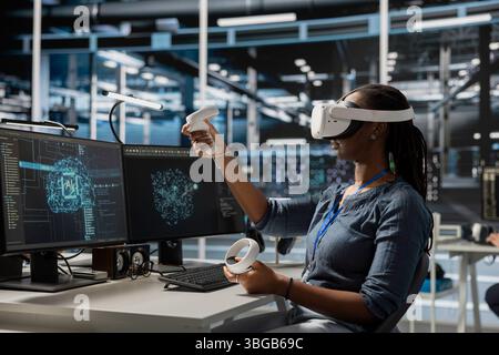 Programmer in data center wearing VR headset using AI powered tech to run simulations. IT expert using virtual reality, coding algorithms to extract insights from data and automate rigs Stock Photo