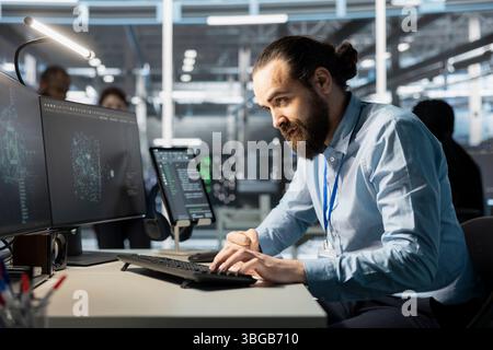 Software developer coding on computer, upgrading artificial intelligence server cabinets doing data intensive operations. IT specialist typing on PC keyboard, updating supercomputers systems Stock Photo