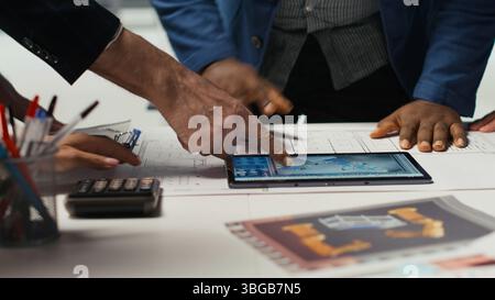 Factory experts designing assembly facility production lines in tablet CAD program. Industrial plant employees using software on device to optimize facility production layouts Stock Photo