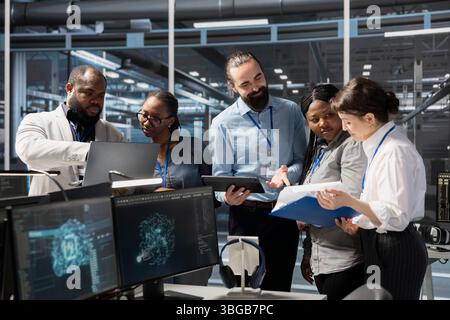 Engineering team working together in data center with artificial intelligence neural networks tech. Server farm staff members cooperating, using AI programming language to update equipment Stock Photo