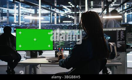 Data center technician using node tree software on green screen PC to ...