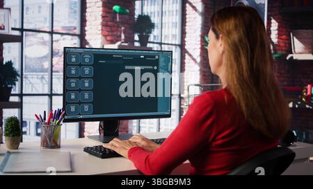 Focused woman working with an AI chatbot on her desktop computer, offering real time assistance and powerful online tools. Advanced system displays how machine learning provides support. Camera B. Stock Photo
