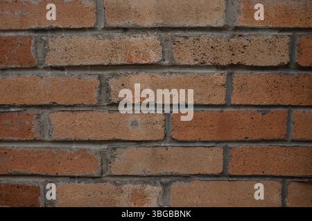 Horizontal rows of red-brown bricks with cement grout lines, ideal textured background for architecture presentations, construction ads, urban desi Stock Photo
