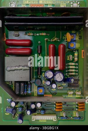 Close-up of a green electronic circuit board featuring various components, resistors, capacitors, and integrated circuits Stock Photo